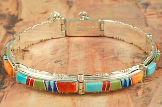 Genuine Sleeping Beauty Turquoise, Spiny Oyster Shell and Blue Lapis inlaid between ribbons of Sterling Silver. Beautiful Fire and Ice Lab Opal Accents. Stunning Sterling Silver Bracelet. Designed by Navajo Artist Calvin Begay. Signed.